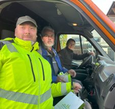 Zwei MItarbeitende der Caritas-Werkstatt und die Bauhof-Leiterin sitzen im Bauhof-Wagen.