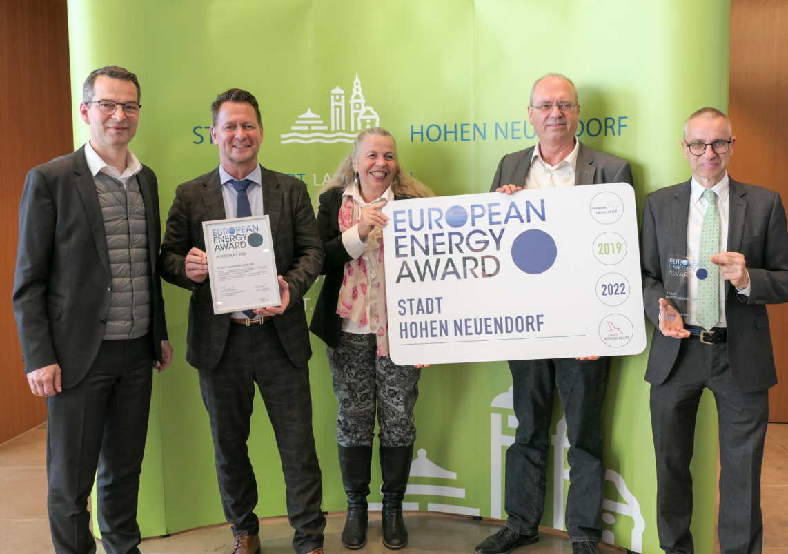 Bürgermeister Steffen Apelt (2.v.l.), Klimaschutzmanagerin Heiderose Ernst (m.) und Stadtverordneten-Vorsitzender Raimund Weiland (r.) nehmen den European Energy Award entgegen.