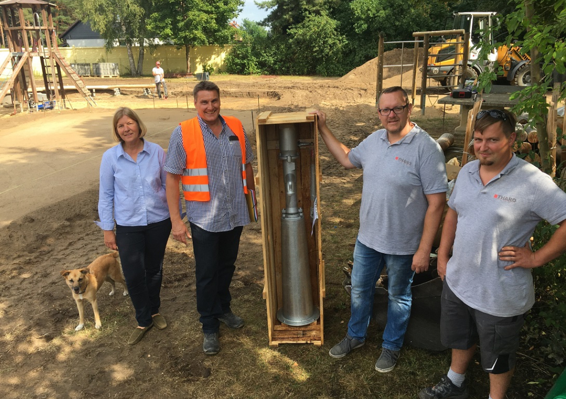 Planerin Verena von Löbbecke, Projektleiter Kai-Uwe John, Bauleiter Magnus Lippoldt und Polier Sven Stuhlträger (v.l.) mit der Schwengelpumpe für den neuen Wasserspielplatz.