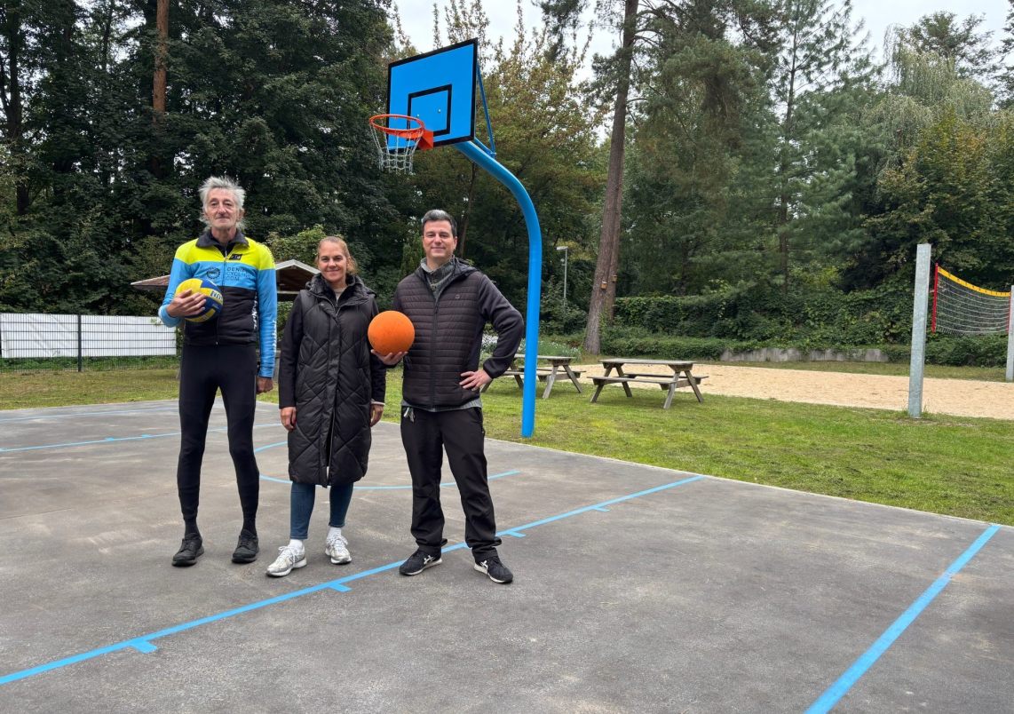 Mitarbeitende Der Stadtverwaltung und das Jugendclubs präsentieren den neuen Basketballkorb am Wasserwerk.