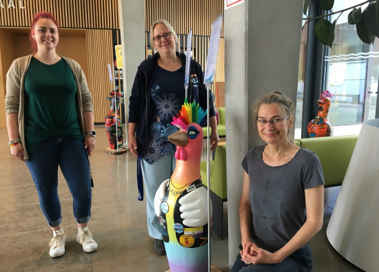 Bunte Hühner: Nicole Florczak (r.) mit ihren Mitstreiterinnen von ImPuls e.V. zusammen mit drei der acht Hühner-Skulpturen im Rathausfoyer.
