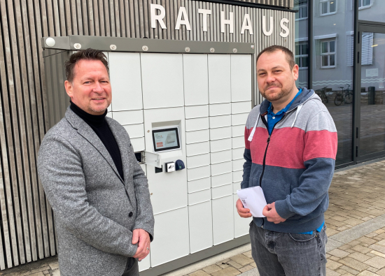 Bürgermeister Steffen Apelt (links) und EMA-Leiter Sebastian Keßler präsentieren den neuen Ausgabeautomaten vor dem Rathaus.