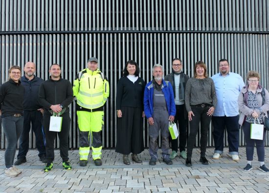 Mitarbeitende der Stadtverwaltung und der Caritas-Werkstatt stehen vor dem Hohen Neuendorfer Rathaus.